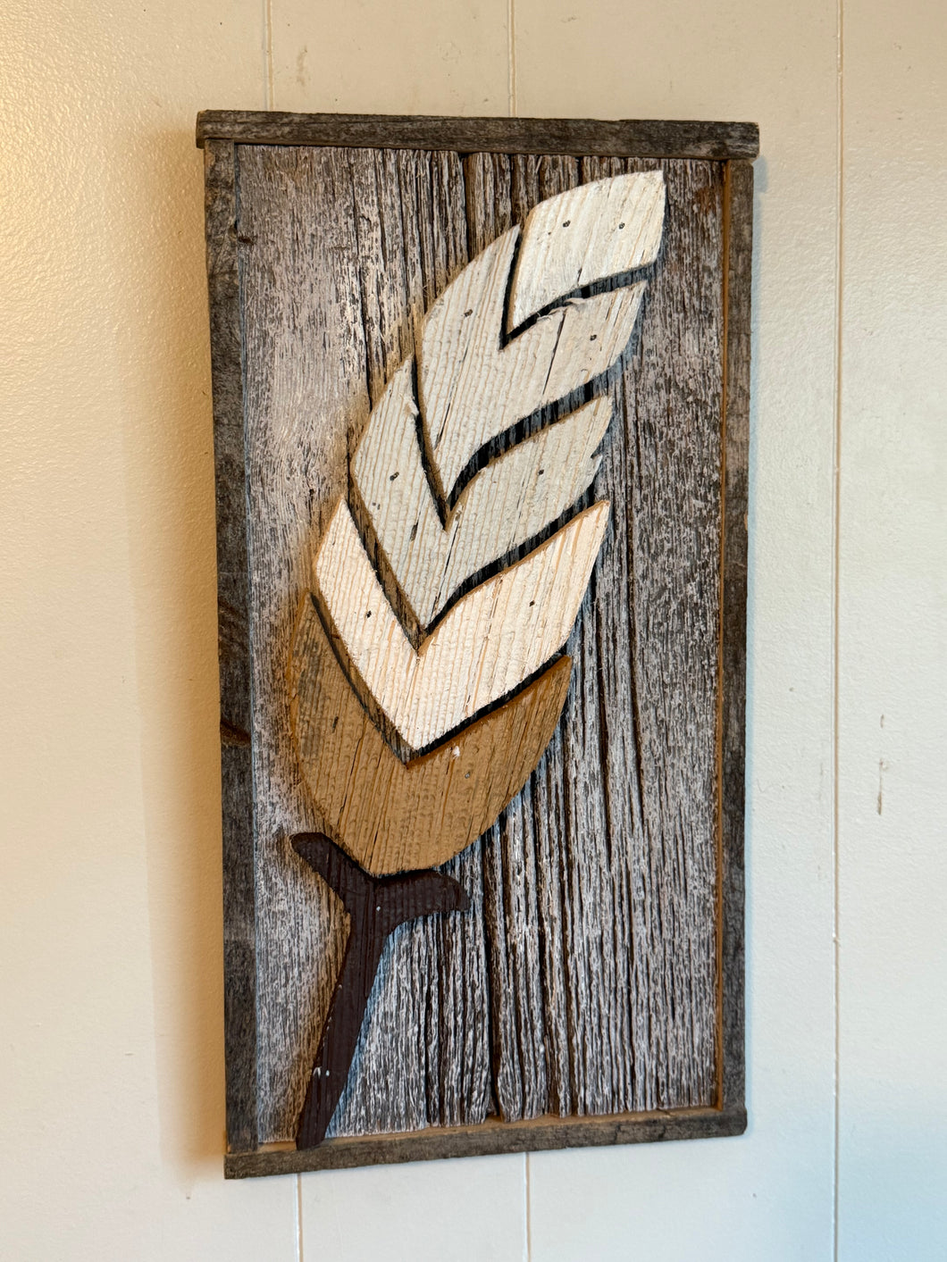 Pieces feather on framed barnboard .